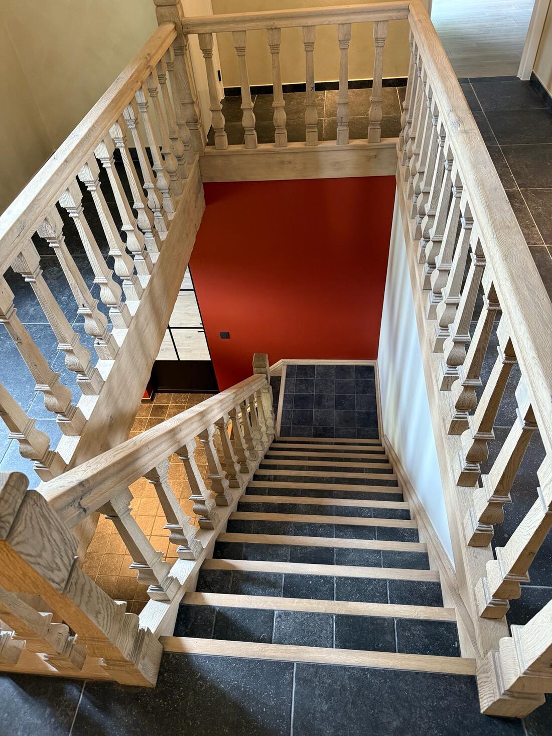 Traphal met natuurstenen treden en witte balustrade